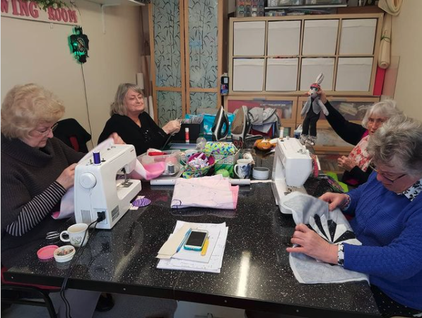 <p>Smiling ladies attending a sewing class</p>